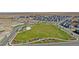 Aerial view of a Primary-planned community featuring lush green spaces, walking paths, and modern residential homes at 9886 Ceylon Ct, Commerce City, CO 80022