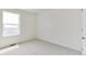 This bedroom features a large window and light carpet at 9886 Ceylon Ct, Commerce City, CO 80022