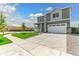 View of the two-story home, the well-kept lawn and a wide driveway at 9886 Ceylon Ct, Commerce City, CO 80022