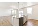 Kitchen island with granite countertop and sink, opening to living room with multiple windows at 9886 Ceylon Ct, Commerce City, CO 80022