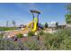 Community playground with a yellow slide, covered climbing structure, and landscaped flower beds at 9886 Ceylon Ct, Commerce City, CO 80022
