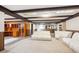 Spacious finished basement featuring decorative ceiling beams, carpet, and built-in storage and shelving at 7190 S Poplar Ct, Centennial, CO 80112