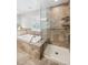 Large neutral bathroom with a glass-enclosed shower and a tiled tub, plus grab bars at 7190 S Poplar Ct, Centennial, CO 80112