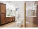 Cozy bathroom featuring a wooden vanity with integrated sink, shower with glass enclosure, and ceramic tile floors at 7190 S Poplar Ct, Centennial, CO 80112