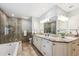 Bright bathroom featuring a soaking tub and a glass-enclosed shower with dual sink vanity at 7190 S Poplar Ct, Centennial, CO 80112