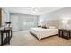 Spacious bedroom with neutral carpet, ceiling fan, big window and large decorative headboard at 7190 S Poplar Ct, Centennial, CO 80112