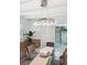 Dining room featuring modern chandelier, glass table and white-shuttered sliding doors for lots of natural light at 7190 S Poplar Ct, Centennial, CO 80112