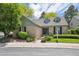 Charming brick home with dormer windows, mature trees, and inviting landscaping at 7190 S Poplar Ct, Centennial, CO 80112