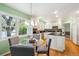 Open eat-in kitchen features white cabinets, black countertops, hardwood floors and stainless steel appliances at 7190 S Poplar Ct, Centennial, CO 80112