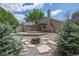 Backyard with stone fire pit, wood deck, and landscaped with trees and rock at 12665 Grove Ct, Broomfield, CO 80020