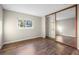 Bright bedroom featuring hardwood floors, natural light, and a mirrored closet at 12665 Grove Ct, Broomfield, CO 80020