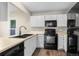 Modern kitchen with black appliances, white cabinets, and a sink with a window view at 12665 Grove Ct, Broomfield, CO 80020