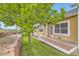 Backyard featuring mature tree, a terraced retaining wall, grass, and exterior of the house at 6727 W Yale Ave, Lakewood, CO 80227