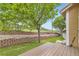 Backyard features a lawn, trees, terraced retaining wall, a wooden deck, and mature landscaping at 6727 W Yale Ave, Lakewood, CO 80227
