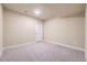 A finished basement area featuring neutral carpet, white base trim, and a door at 6727 W Yale Ave, Lakewood, CO 80227
