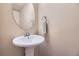Well-lit half bathroom featuring a pedestal sink, decorative mirror and neutral wall color at 6727 W Yale Ave, Lakewood, CO 80227