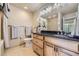 Bright bathroom featuring a granite countertop vanity, decorative lighting and neutral tones at 6727 W Yale Ave, Lakewood, CO 80227