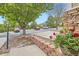 A vibrant street view featuring a stone wall, healthy trees, flowerbeds, and neighboring houses at 6727 W Yale Ave, Lakewood, CO 80227