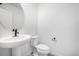 Bathroom boasts a sleek pedestal sink, round mirror, modern fixtures, and a convenient toilet at 5688 N Killarney Ct, Aurora, CO 80019