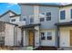 Modern townhome with varied siding, covered entry, and a bright yellow front door and manicured landscaping at 5688 N Killarney Ct, Aurora, CO 80019