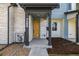 Close-up of a townhome's welcoming yellow front door, framed by stone and a covered porch at 5688 N Killarney Ct, Aurora, CO 80019