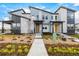 Modern townhome with stone accents, tidy landscaping, a walkway and a sunny yellow front door at 5688 N Killarney Ct, Aurora, CO 80019