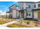 A modern townhome with stone accents, xeriscaping, and a bright yellow front door under a covered porch at 5688 N Killarney Ct, Aurora, CO 80019