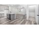 Modern kitchen features an island, gray cabinets, stainless steel appliances, and wood flooring throughout the living space at 5688 N Killarney Ct, Aurora, CO 80019