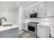 Modern kitchen featuring gray cabinets, stainless steel appliances, and subway tile backsplash and modern faucet at 5688 N Killarney Ct, Aurora, CO 80019