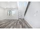 Bright and airy living room featuring gray flooring, an open staircase and modern front door at 5688 N Killarney Ct, Aurora, CO 80019