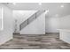 Sunlit living room with open staircase, modern railing and neutral gray flooring, offering a spacious feel at 5688 N Killarney Ct, Aurora, CO 80019