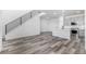 Open-concept living room with wood floors, a staircase with metal railings, and a view into the modern kitchen at 5688 N Killarney Ct, Aurora, CO 80019