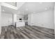 Spacious living area with wood floors, leading to a modern kitchen with gray cabinetry and a center island at 5688 N Killarney Ct, Aurora, CO 80019