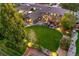 Aerial view of the home showcasing the backyard with a lush lawn, pergola, deck, and landscaped garden at 7678 Newman St, Arvada, CO 80005