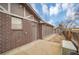 Exterior view of backyard with a shed, brick siding, and concrete walkway leading to a side door at 7678 Newman St, Arvada, CO 80005