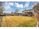 Expansive backyard with a large lawn, detached rec room, deck, and pergola with seating area at 7678 Newman St, Arvada, CO 80005