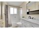 Clean bathroom featuring white subway tile, a bathtub and shower, a gray shower curtain, and a modern vanity at 7678 Newman St, Arvada, CO 80005