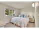 Comfortable bedroom featuring a plush queen bed, soft blue pillows, a quaint bedside table, and a bright window at 7678 Newman St, Arvada, CO 80005