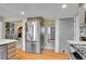 Bright kitchen featuring stainless steel appliances, hardwood floors, and convenient access to other living spaces at 7678 Newman St, Arvada, CO 80005