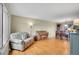 Well-lit living room featuring hardwood floors, piano, and adjacent dining area at 7678 Newman St, Arvada, CO 80005