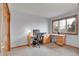 Bright office space with a large window, a neutral color scheme, and a built-in wooden desk with ample storage at 7678 Newman St, Arvada, CO 80005