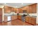 Kitchen with wood cabinetry, stainless steel appliances, hardwood floors, and granite countertops at 3058 Bergen Point Trl, Evergreen, CO 80439