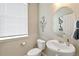 Small bathroom with pedestal sink and toilet at 43175 Merion Hills Ct, Elizabeth, CO 80107