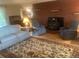Cozy living room with a brick fireplace, plush seating, and hardwood floors at 14751 E 24Th Ave, Aurora, CO 80011