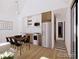Bright, open-concept kitchen and dining area with sleek white cabinets, stainless steel appliances, and modern dining set at 769 Turner St, Erie, CO 80516