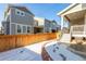 View of the backyard featuring a wooden fence, snow-covered lawn, and porch at 17470 E 95Th Pl, Commerce City, CO 80022