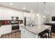 Modern kitchen with white cabinets, stainless steel appliances, and a spacious island with bar seating at 17470 E 95Th Pl, Commerce City, CO 80022