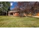 Two-story brick home with a spacious lawn, mature trees, and a long driveway at 5292 Lichen Pl, Boulder, CO 80301