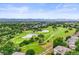 Expansive aerial view showcasing the golf course community, with a backdrop of distant mountains and blue skies at 6105 W Long Dr, Littleton, CO 80123