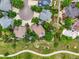 Aerial view of the home nestled amongst mature trees on a landscaped lot with a pool and walking paths at 6105 W Long Dr, Littleton, CO 80123